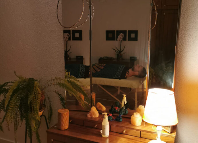 Komoda z olejkami do masażu, lampą i lustrem w gabinecie Studio ASA